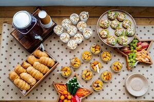 A beautifully arranged table that is topped with a delightful variety of food and drinks that cater to diverse tastes and preferences, creating a feast for everyone to enjoy photo