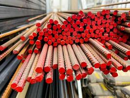 A meticulously organized and arranged stack of vibrant red metal bars forms a visually striking and appealing structure that highlights the beauty of these materials and their arrangement photo