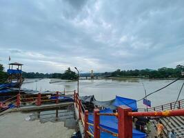 In the distance, one can observe a large body of water, and there is a bridge elegantly positioned in the background, creating a picturesque scene of nature and architecture photo