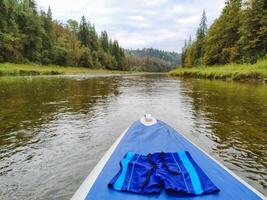 A pair of blue shorts sits on the front of a paddle board photo