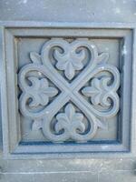 A gray square that prominently features a striking, intricate, and beautiful floral design on its surface, showcasing the depth of artistic creativity and meticulous attention to detail photo