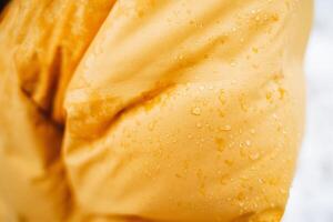 A closeup highlights sparkling water droplets on vibrant yellow fabric, showcasing the fusion of nature and contemporary fashion, creating a captivating visual experience photo