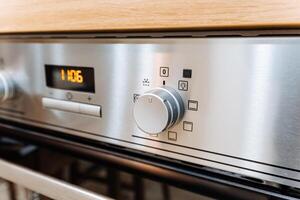 The image showcases a sleek and shiny stainless steel oven that features a modern digital display, enabling effortless operation and precise temperature control for all your cooking needs photo