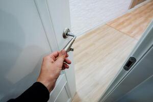 A person is in the process of opening a door while holding a key firmly in their hand, ready to unlock it and gain entry. It is an everyday action that we often take for granted photo
