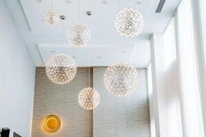 The room in question features a substantial number of lights elegantly suspended from the ceiling, creating a luminous and vibrant atmosphere that enhances the overall ambiance photo