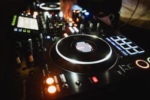 An impressive and professional DJ equipment setup featuring turntables and controllers within a vibrant nightclub setting, perfect for lively parties photo