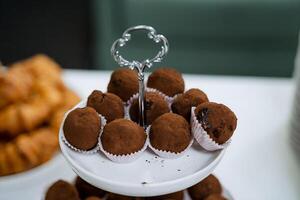 A white plate elegantly showcases chocolate truffles, a tempting dessert treat, creating a delightful presentation on the table for dessert lovers to enjoy the rich and indulgent flavors photo