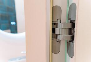 A detailed close up view of a door hinge positioned securely on a door, showcasing its design and functionality, clearly highlighting its significance in door operations photo