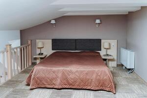 In the center of the room, there is a large and incredibly spacious bed that takes up a significant amount of space, providing both comfort and a central focal point for the entire area photo