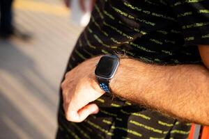 A man is seen with a stylish and modern smart watch adorning his wrist, which showcases the latest technology and trends in wearable accessories, catching the eye of passersby photo