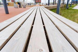 Closeup of hardwood bench with parallel wooden planks in park photo