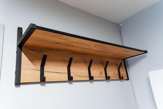 un hermosamente hecho a mano de madera estante, completar con manos adjunto para colgando varios elementos, es esmeradamente desplegado en un muro, agregando ambos funcionalidad y estético apelación a el espacio foto