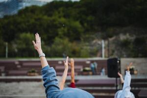 A lively group of people, full of energy and enthusiasm, are collectively raising their hands high up into the air, showing excitement and joy during a shared experience together photo