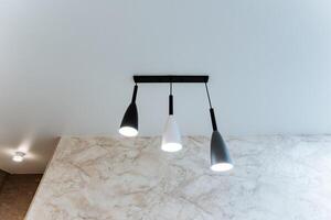 There exists a beautiful ceiling light that comes equipped with three individual lights that elegantly hang down from it, adding both illumination and style to the entire room photo