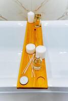 Wooden bathtub tray with candles and soap, fashion accessory for a relaxing bath photo
