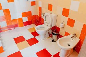 A fully equipped bathroom featuring a toilet, a bidet, and a sink, designed for maximum functionality and comfort, suitable for everyday personal hygiene needs and convenience photo