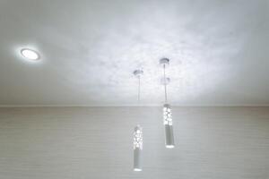 The modern ceiling features elegant pendant lights and downlights for a sophisticated and stylish lighting design photo