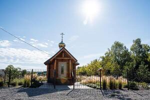 There is a quaint and charming small wooden church that features a cross majestically situated on the very top of its roof, making it an unmistakable landmark in the area photo