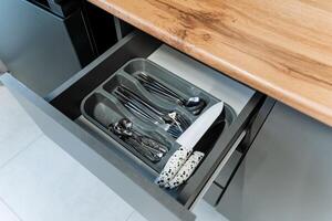 This modern kitchen drawer features a stylish and efficient cutlery organizer that is specifically designed to hold forks, knives, and spoons, keeping your kitchen neat and tidy photo