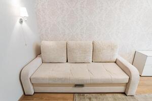 A beige sofa enhances the minimalist living room look, creating a chic, clean, and comfortable space photo