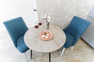 Imagine a lovely, charming dining table set for two, accompanied by two comfortable chairs, and a beautifully arranged plate of delightful food, all eagerly waiting to be enjoyed photo