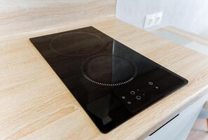 A beautiful stove top oven is elegantly situated on a charming wooden counter in a welldesigned kitchen, which is fully equipped and ready for creating delicious and delightful meals photo