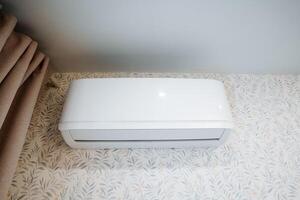 A modern white air conditioner is installed in the room, providing a cool and comfortable atmosphere, which enhances the indoor experience and satisfaction for all occupants photo