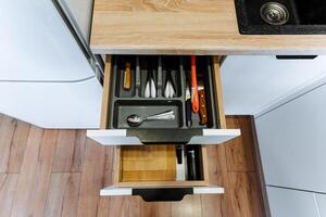 This kitchen features a standout drawer that is filled with a fascinating assortment of utensils and knives, showcasing its careful organization and specific purpose for culinary tasks photo