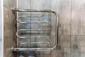 A sleek and stylish towel rack elegantly hangs on the bathroom wall, skillfully serving a practical function while significantly enhancing the overall aesthetic charm of the space photo