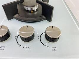 This image shows a detailed closeup view of a gas stove featuring four distinct knobs on its surface, which are used to control the burners on this essential kitchen appliance photo