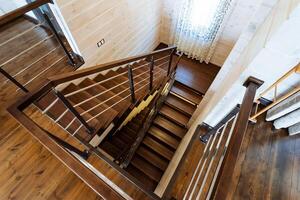 A beautifully crafted wooden staircase with a sleek metal railing gracefully integrated within the interior of a modern house, adding both functionality and aesthetic appeal photo
