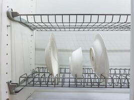 A dish rack that is holding various plates and bowls neatly arranged on it, showcasing an organized kitchen space, contributing to a functional and aesthetic home environment photo