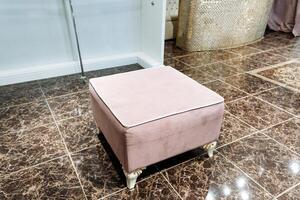 A soft pink ottoman is peacefully placed on a beautifully tiled floor in a charming and cozy room, contributing to an inviting atmosphere filled with comfort, elegance, and style photo