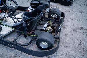 A go kart is currently parked on the side of the road, waiting for its next ride or adventure. It is a small, fast vehicle commonly enjoyed in racing scenarios or recreational areas photo