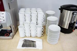 A stack of coffee cups and saucers on a table contributes to a cozy atmosphere, reflecting warmth and hospitality, creating a welcoming environment for guests with a comforting touch photo
