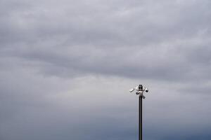 A Dramatic Sky Featuring a Light Pole in an Overcast Environment That Enhances the Overall Atmosphere and Mood photo