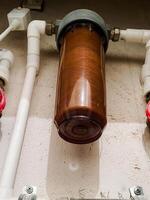 Here is a closeup view of a water filter that features striking red handles, which adds a vibrant touch to its design and functionality, making it an essential part of plumbing photo