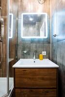 Imagine a cozy bathroom with a stylish sink, a large mirror, and a refreshing shower, all designed to enhance your daily routines and provide a soothing space for relaxation photo