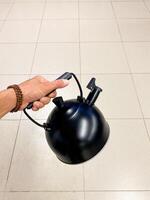 The illustration depicts a person with a black pot on a tiled surface, highlighting gestures, art, and engineering. These elements are prominently featured in the artwork photo