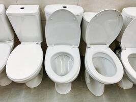 In a restroom, you can see a neat row of pristine white toilets meticulously arranged in a straight line, presenting a clean and organized appearance for users to enjoy their experience photo