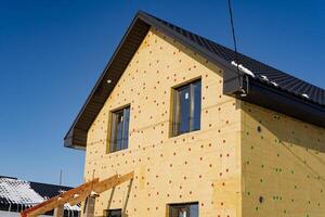 Insulation of the building with mineral wool, the country house is sheathed with insulation, installation of thermal panels, construction of the house. photo