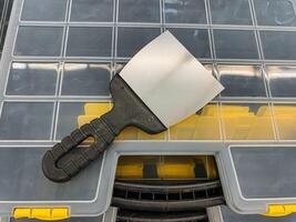 A kitchen utensil, specifically a spatula, is resting on the lid of a plastic container, possibly waiting to be used for cooking or preparation tasks, showcasing a casual kitchen scene photo
