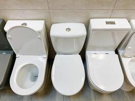 In the spacious and welldesigned bathroom, a neat row of gleaming white toilets is perfectly aligned, ensuring maximum convenience and comfort for all users to enjoy their experience photo