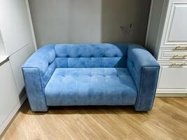 A stunning blue couch situated on a warm wooden floor creates a cozy, inviting atmosphere that is perfect for relaxation and enjoyment in this comfortable living space designed for comfort photo