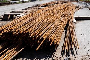 Rusty steel rebars stacked at construction site, essential building materials for reinforced concrete. Raw materials for infrastructure development in industrial projects photo