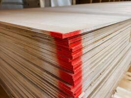 A prominently stacked and organized pile of plywood, carefully arranged with a distinct red stripe on one corner, gives it a unique and stylish appearance that truly catches the eye photo