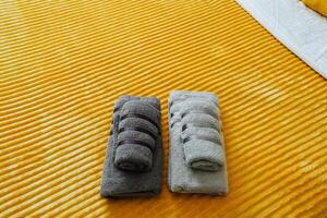 Fresh towels are neatly stacked on the bed, ready for a revitalizing shower, contributing to the rooms cozy feel. Their softness and comfort enhance the relaxing atmosphere photo