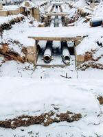 Scattered haphazardly across the pristine white snow, an assortment of pipes of different sizes creates a striking visual contrast against the beautiful and icy winter landscape photo