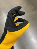 This closeup image of a workers glove features a striking black and yellow pattern, highlighting the craftsmanship and expertise important in their tasks photo
