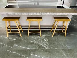 In the space before a kitchen island, three wooden stools are neatly arranged, creating a welcoming and functional area perfect for casual dining or conversations over coffee photo